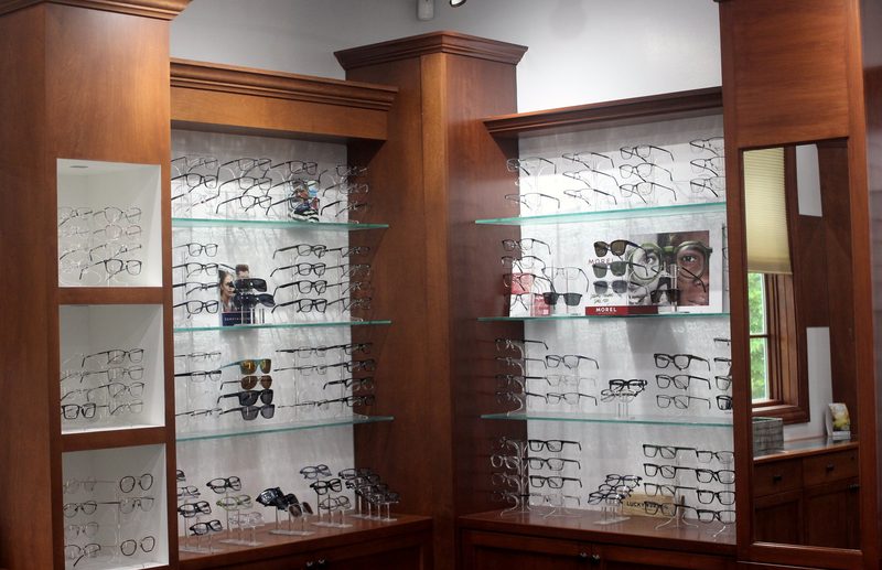 Wood-and-glass wall display of designer eyeglass frames in COVE's optical in New Albany